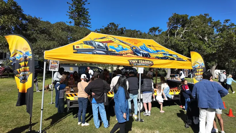 Tiny Tradies branded marquee at a live outdoor event